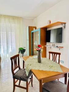 un tavolo da pranzo con un vaso di fiori sopra di La casa di Biu a Gela