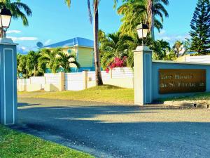 a sign in front of a house with palm trees at Villa Douceur & Spa Piscine & Jacuzzi privés - proche plage in Saint-François
