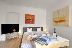 1 dormitorio con 1 cama con mesa y TV en Casa di Tino - Happy Rentals, en Losone 5 fotos más