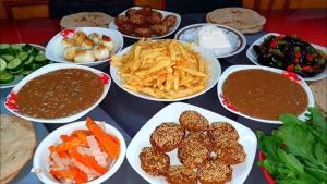 a table with plates of food and bowls of dip at Dangy Kato in Aswan