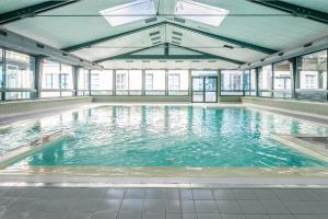 a swimming pool with blue water in a building at Immodély & la Parade de Disney in Serris