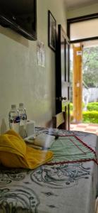 a bed with a yellow blanket and two bottles of water at Complejo Don Pascual in San Pedro La Laguna