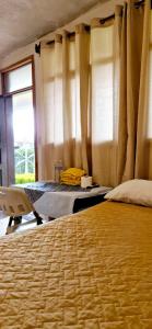 a bedroom with a bed and a table and a window at Complejo Don Pascual in San Pedro La Laguna +91 photos