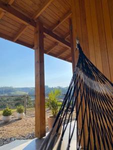 a hammock on a porch of a house with a view at Casa de Campo in Barracão