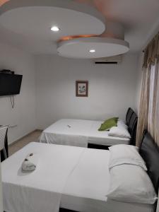 Postel nebo postele na pokoji v ubytování Hotel La Leyenda Vallenata