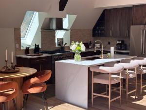 a kitchen with a white island with chairs and a counter at Luxury Escape in McCall in McCall