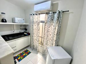 a kitchen with white cabinets and a window at Studio Brownie em Capim Macio in Natal