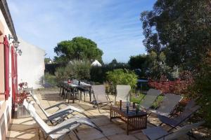 a patio with chairs and a table and a table and chairs at Maison au calme dans village fleuri - Jardin clos in Locmaria
