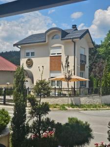 a large white building with a black roof at Montain House Rakocevic in Kolašin