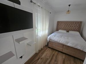 a bedroom with a bed and a flat screen tv at Montain House Rakocevic in Kolašin +5 photos