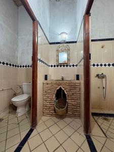 a bathroom with a toilet and a brick fireplace at berber desert home for rent in Merzouga +21 photos