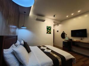 a hotel room with a bed and a flat screen tv at Plato De Ciudad II in Boracay