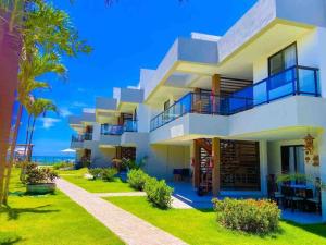 a large white building with a yard at Casa Turquesa in Itacimirim