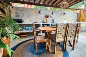 a wooden table and two chairs in a room at Casa Turquesa Pé na areia Piscina infinita Pet friendly Condomínio fechado in Itacimirim