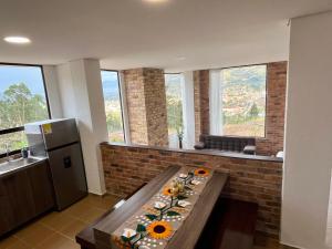 a kitchen with a table with flowers on it at La Violeta in Tibasosa