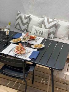 a table with plates of food and wine on a couch at Maison pecheur dans le banzeau in Noirmoutier-en-l'lle +59 photos