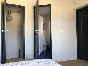 a bedroom with a bed and a bathroom with a toilet at Maison pecheur dans le banzeau in Noirmoutier-en-l'lle