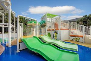 a playground with a green slide in a park at Turtle Beach Tropical Bliss in Gold Coast