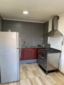 a kitchen with a stainless steel refrigerator and red cabinets at Chalet Mar del Plata in Mar del Plata
