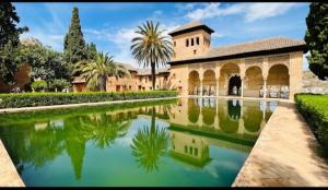 a building with a reflection in a pool of water at Casa Rural Maria in Pinos Genil