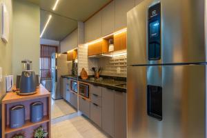 a large kitchen with a stainless steel refrigerator at Brasília a 400m do metrô in Brasilia +41 photos