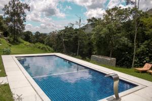 a swimming pool in the middle of a yard at Vale Das Araras Nas Videiras in Araras Petropolis