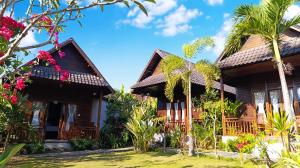珀尼达岛Kurnia Guest House & Spa的一栋门前有棕榈树的房子