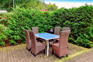 a table and chairs on a patio with bushes at Strandhaus in Heringsdorf