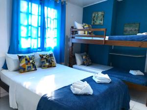 two beds in a room with blue walls at Pousada Turquesa By Gente Bonita in Búzios +71 photos