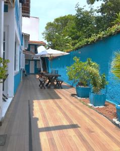 a wooden deck with a picnic table and umbrella at Pousada Turquesa By Gente Bonita in Búzios +60 photos