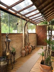 a room with vases and plants on a wooden floor at Charmosa Cabana Passarim, Gonçalves, Costas in Paraisópolis