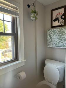 a white bathroom with a toilet and a window at Spacious Relaxing Baltimore Home with Hot Tub in Baltimore