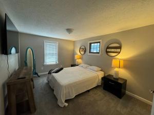 a bedroom with a bed and a table and a mirror at Spacious Relaxing Baltimore Home with Hot Tub in Baltimore