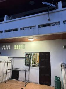 een wit gebouw met een zwarte deur en een balkon bij 2 Bedroom Townhouse in Koh Samui 