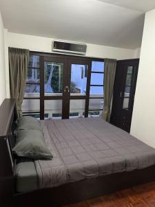 een slaapkamer met een bed en een televisie aan de muur bij 2 Bedroom Townhouse in Koh Samui 
