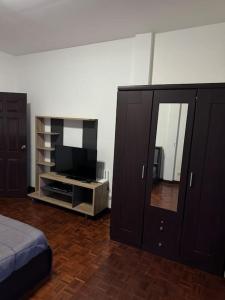 een slaapkamer met een tv en een entertainmentcentrum bij 2 Bedroom Townhouse in Koh Samui  +9 foto's