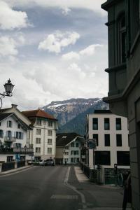 uma rua da cidade com edifícios e uma montanha ao fundo em Nimbuzzz Apartments em Unterseen mais 25 fotografias
