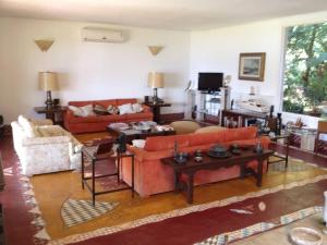 a living room with couches and tables at Mansão Panorâmica Angra dos Reis in Angra dos Reis