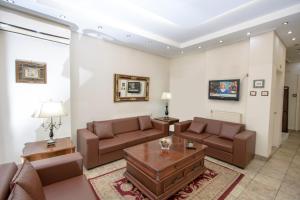 فندق أثينا دلتا في أثينا: غرفة معيشة مع كنب وطاولة قهوة