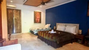 a bedroom with two beds and a blue wall at Apartment Nine at the Bayshore Resort Candidasa in Candidasa +26 photos