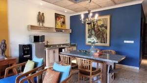 a kitchen with a dining table and a blue wall at Apartment Nine at the Bayshore Resort Candidasa in Candidasa