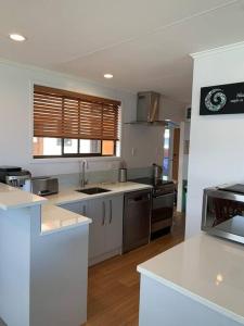 a large kitchen with white counters and appliances at Beautiful Lakefront Location in Rotorua