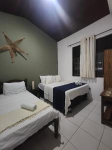une chambre avec deux lits et une étoile sur le mur dans l'établissement Casa de Praia - Ilha da Crôa - Barra de Sto Antônio, à Barra de Santo Antônio 92 autres photos