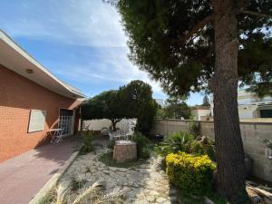 a backyard with a tree and a brick building at Villa Marina con 10 posti letto a 350 mt dal mare in Campomarino