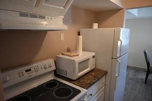 una cucina con forno a microonde e frigorifero di Elgin Suite a Niagara Falls Altre 4 foto