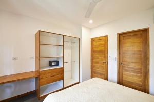 a bedroom with a bed and a wooden cabinet at Green Turtle Townhome #3 Private Pool & Garden 300 Mt to Beach in Tamarindo +10 photos