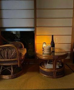 a table with a bottle of wine and a chair at Vacation house月yue in Tokushima