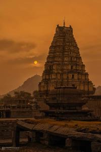 ein großes Gebäude mit Sonnenuntergang im Hintergrund in der Unterkunft Khushi's Paradise Villa hampi in Hampi + 48 Fotos