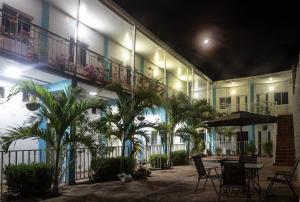 a courtyard of a building with a table and palm trees at Palaa Mujuii Hotel in Dibulla