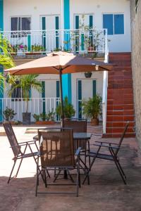 a table and chairs with an umbrella on a patio at Palaa Mujuii Hotel in Dibulla